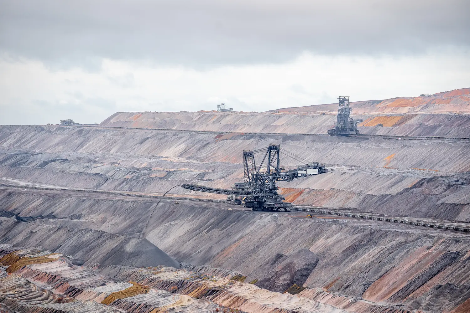 Open-cast mine with terraced benches and bucket-wheel excavators at work